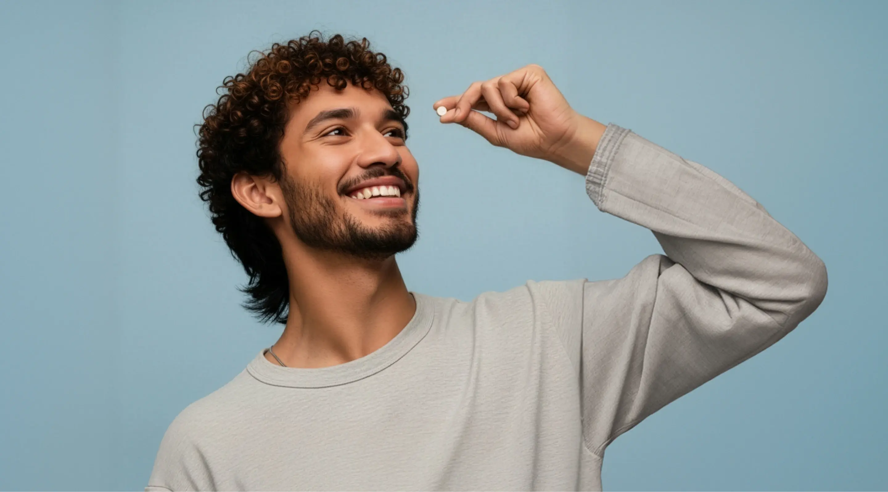 Young Latin man taking a pill