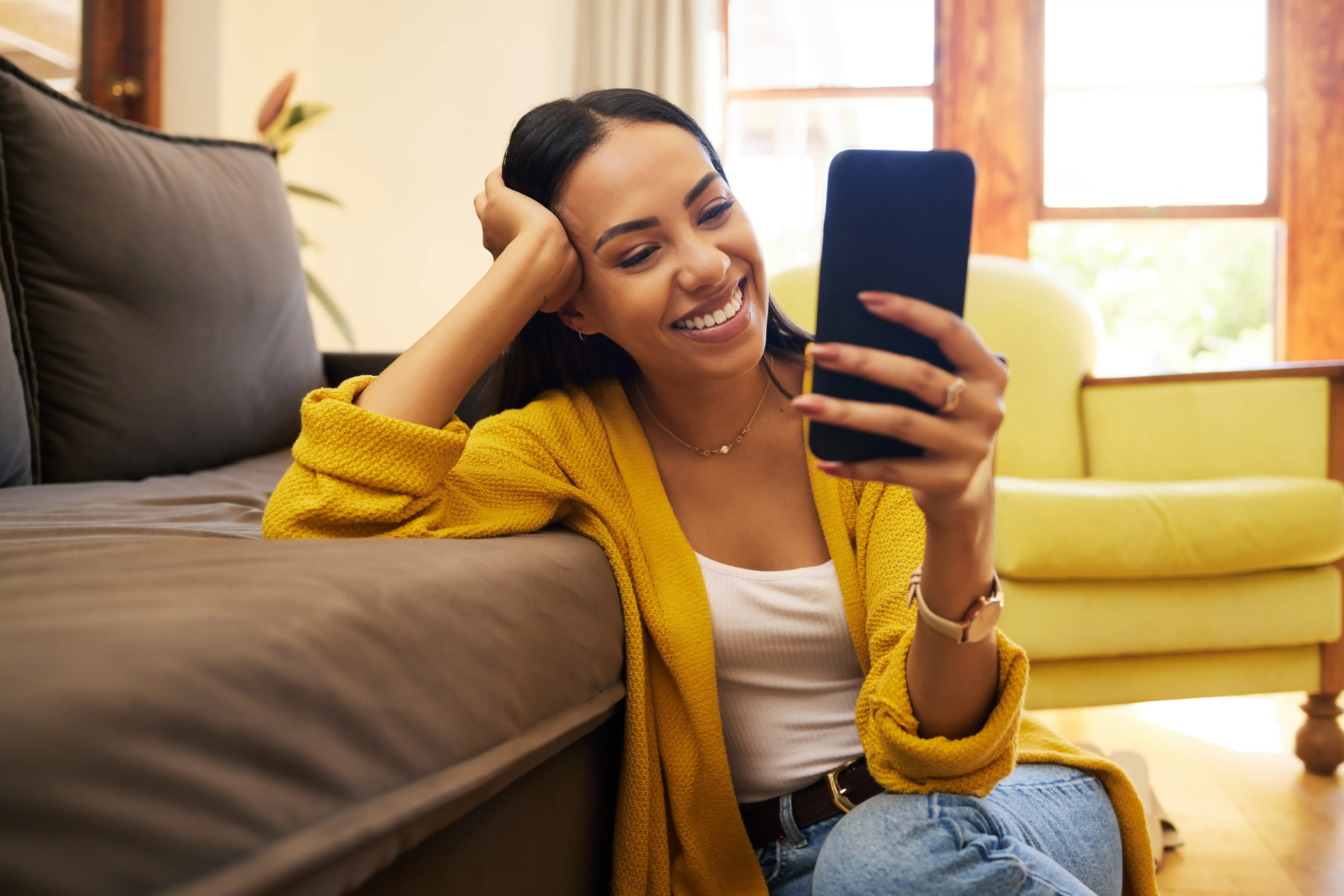 A woman smiling at her phone